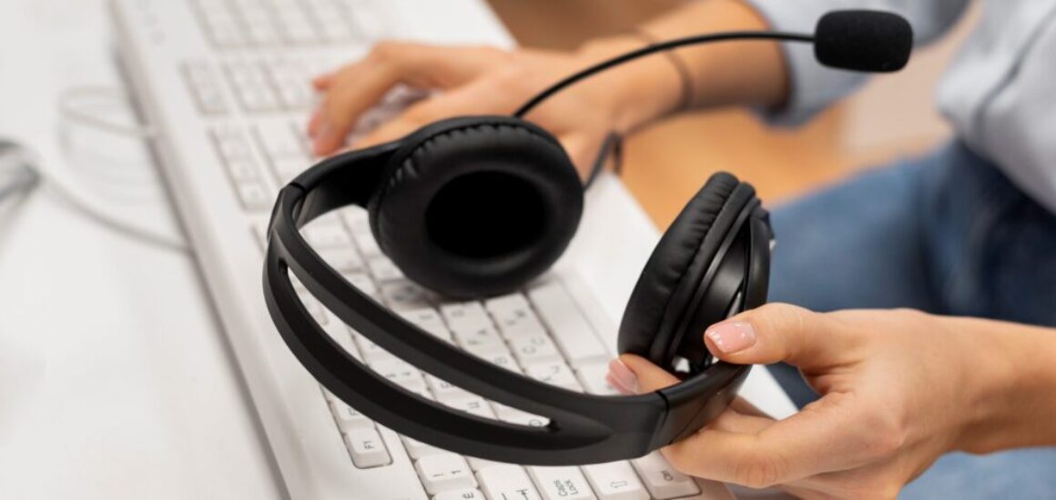 woman-working-call-center-holding-pair-headphones-scaled