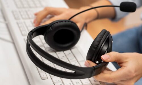 woman-working-call-center-holding-pair-headphones-scaled